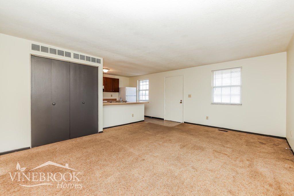 A room with a carpeted floor and a logo that says Vinebrook Homes.