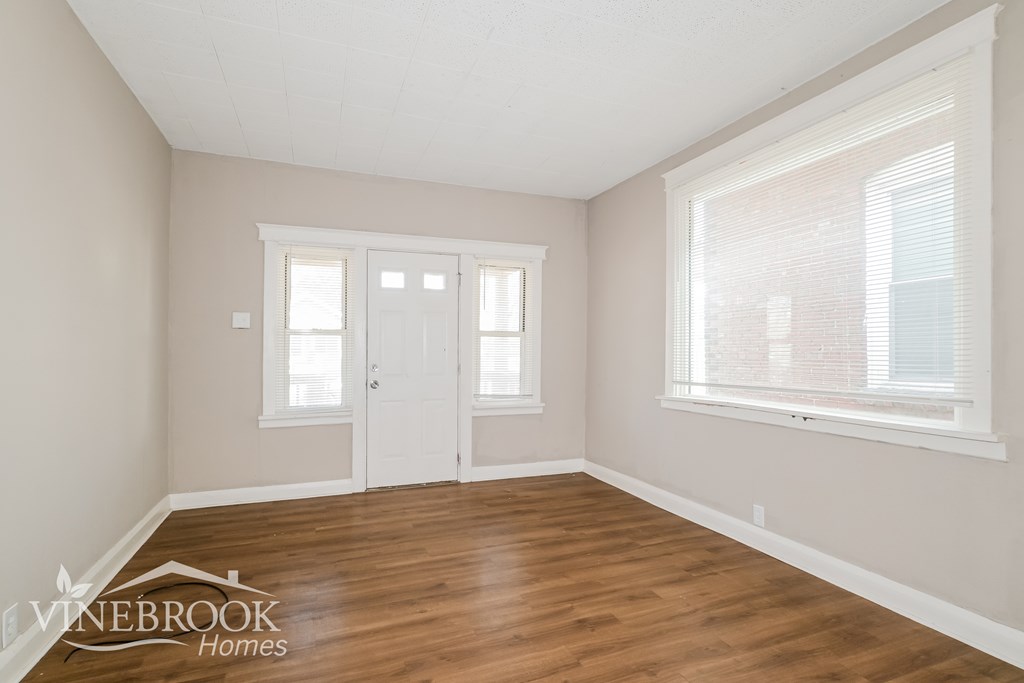 A room with a white door and a window with blinds.