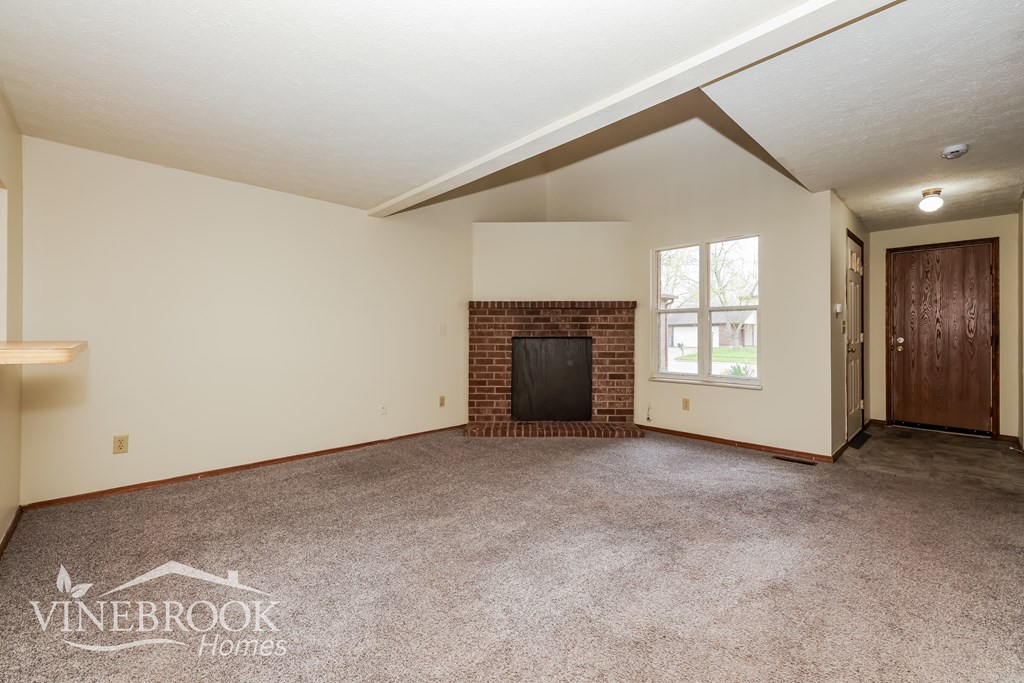 A room with a fireplace and a window.