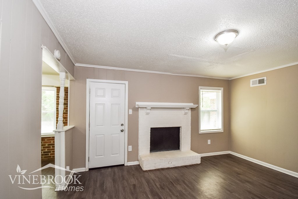 A room with a fireplace and a door.