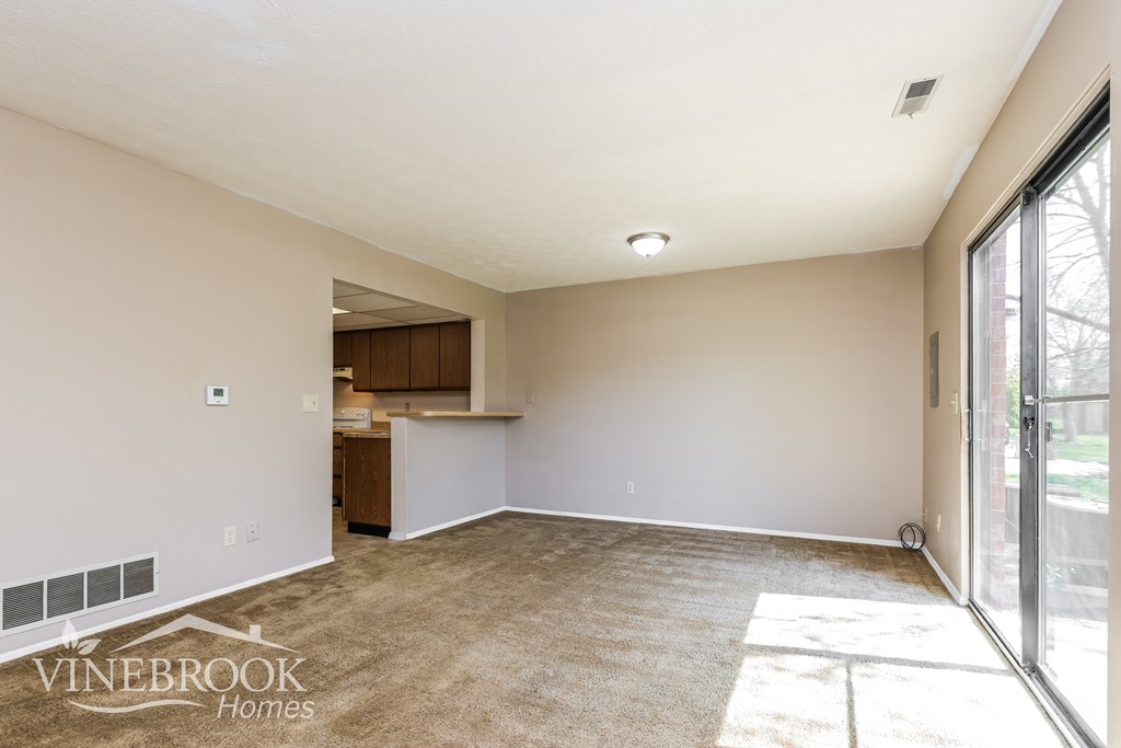 A spacious room with a carpeted floor and a Vinebrook Homes logo.
