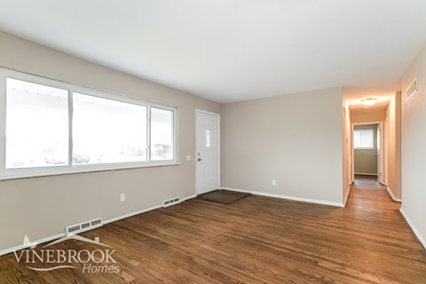 A room with wooden floors and a large window.