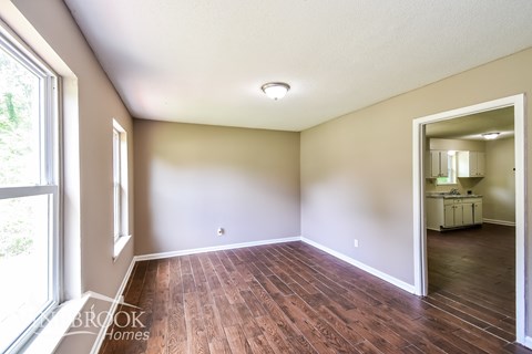 A room with wooden floors and a large window.