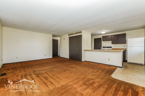 A room with a kitchenette and a refrigerator in it.