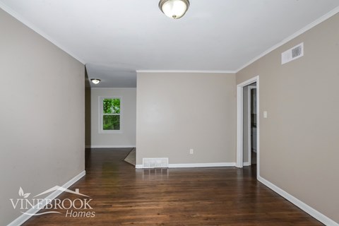 A room with a wooden floor and a painting on the wall.
