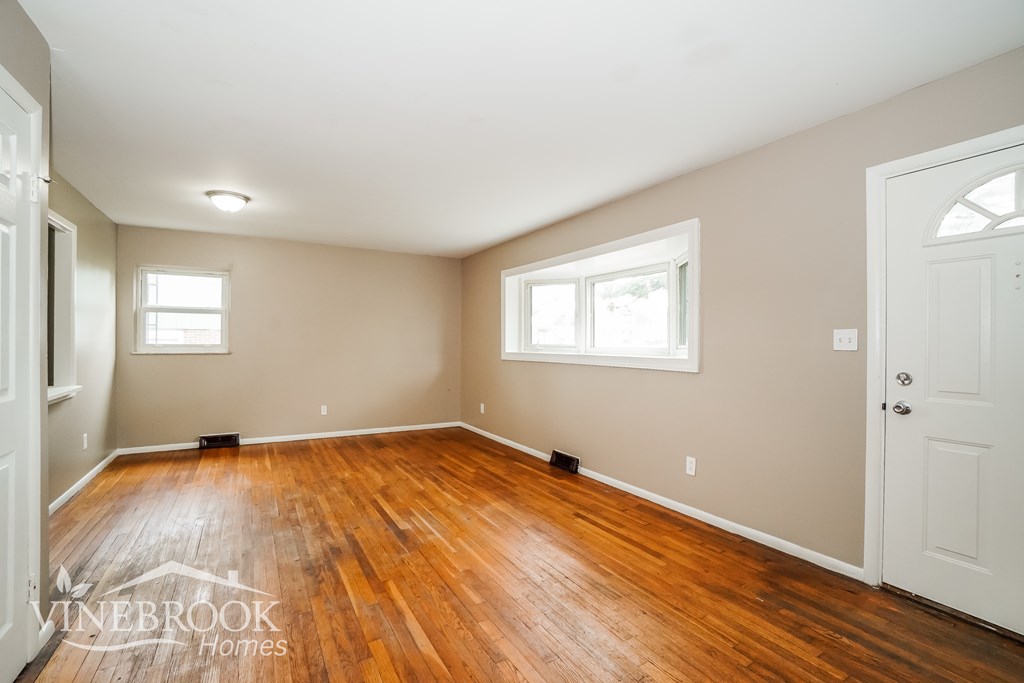 A room with wood floors and white walls.