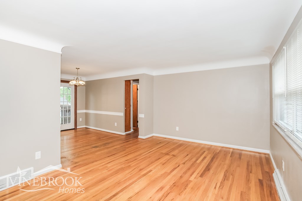A room with wooden floors and a chandelier.