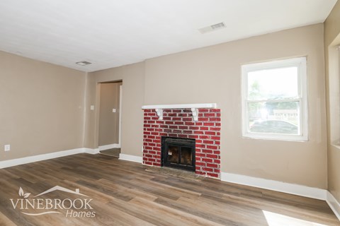 A room with a fireplace and a window.