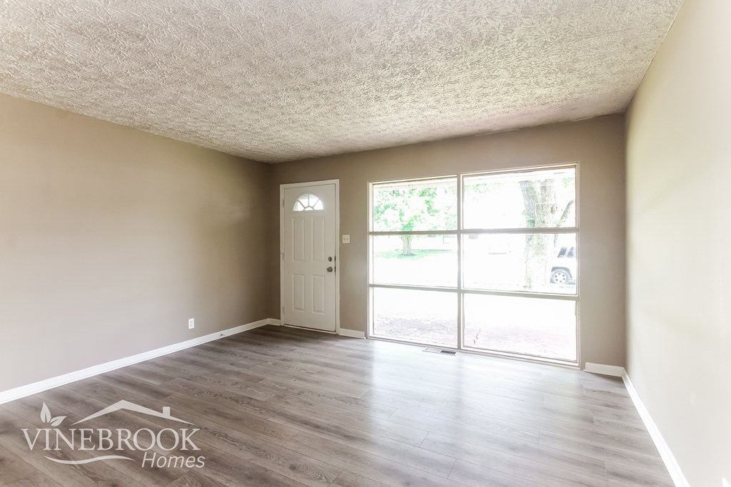 A room with a sliding glass door leading to a backyard.
