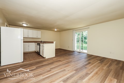 A kitchen with white cabinets and a wooden floor.