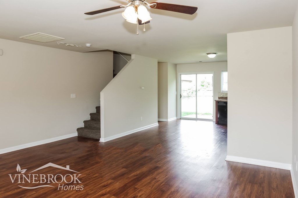 A room with a staircase and a ceiling fan.