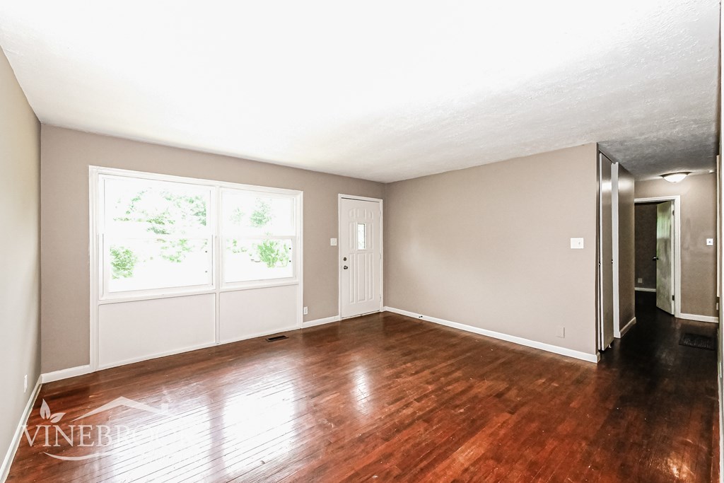 A room with wood floors and a large window.