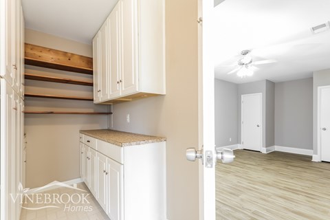 A kitchen with white cabinets and a countertop is shown.