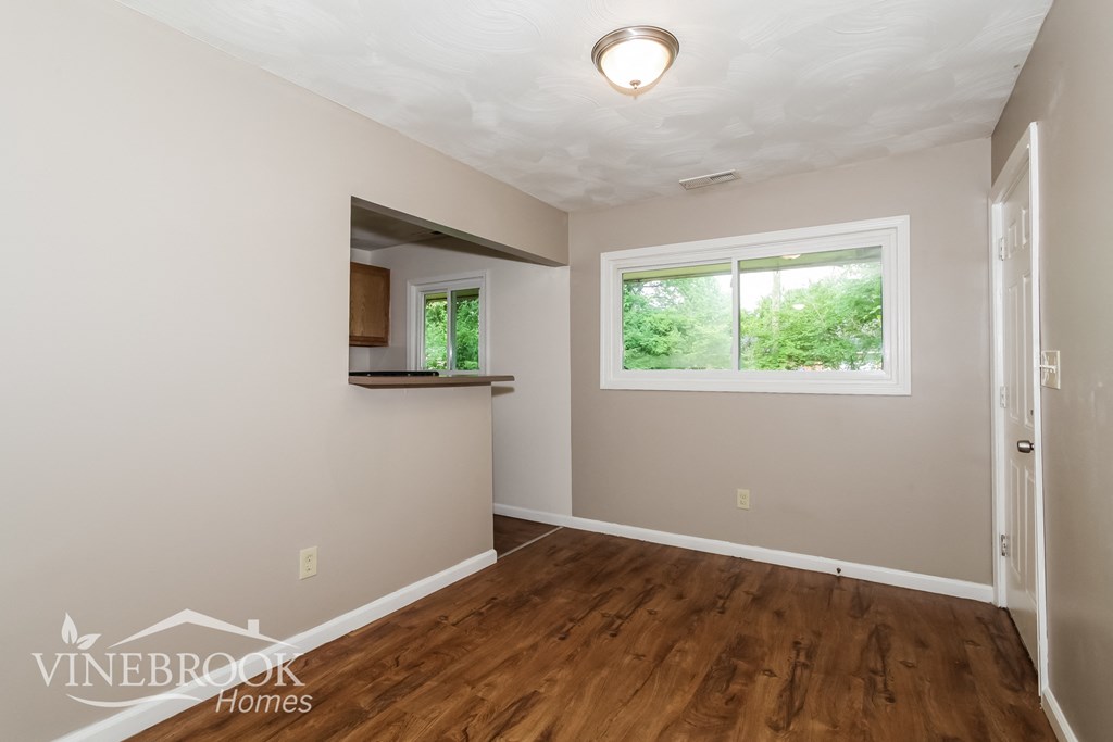 the living room of a home with a hardwood floor and a window