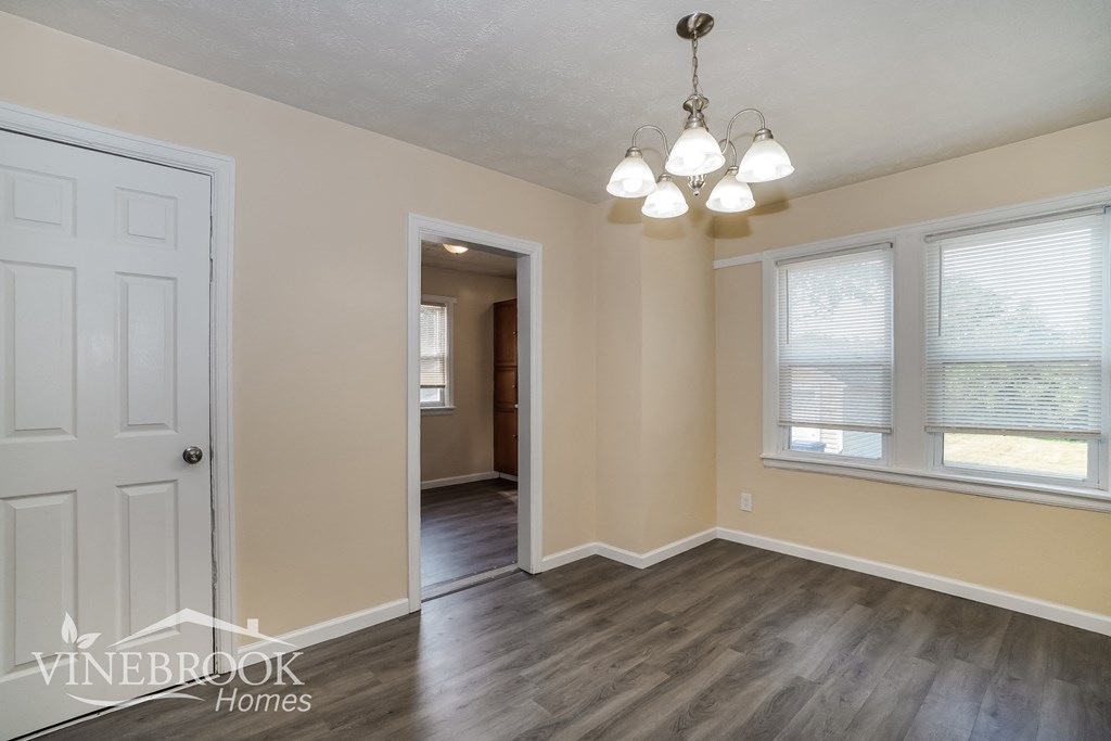 the living room and dining room with the door to the hallway