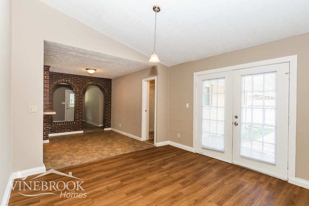 the living room and dining room of a house with wood flooring