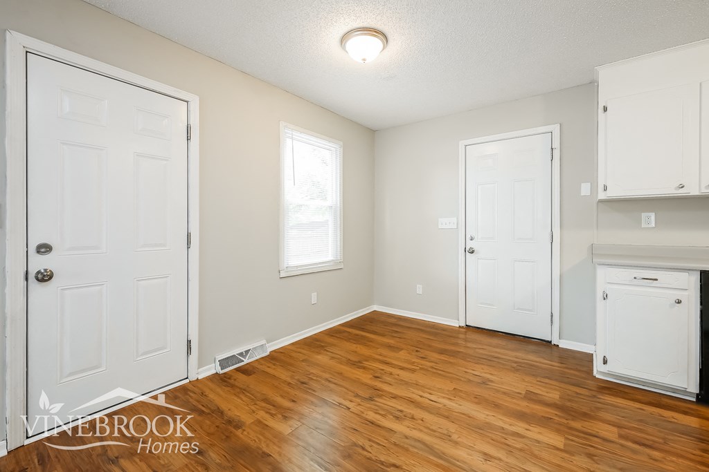 a living room with a hard wood floor and white doors