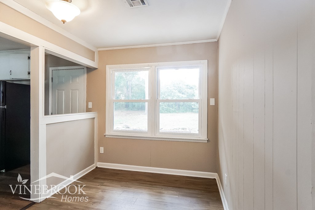 a small room with a window and a wooden floor