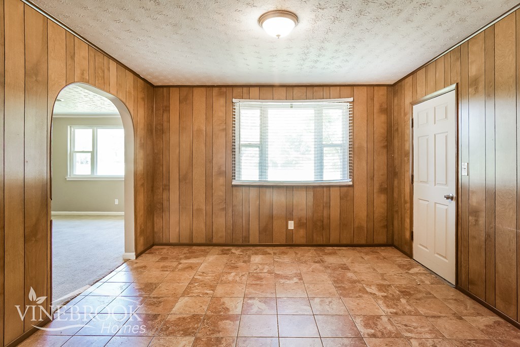 an empty living room with a door and a window