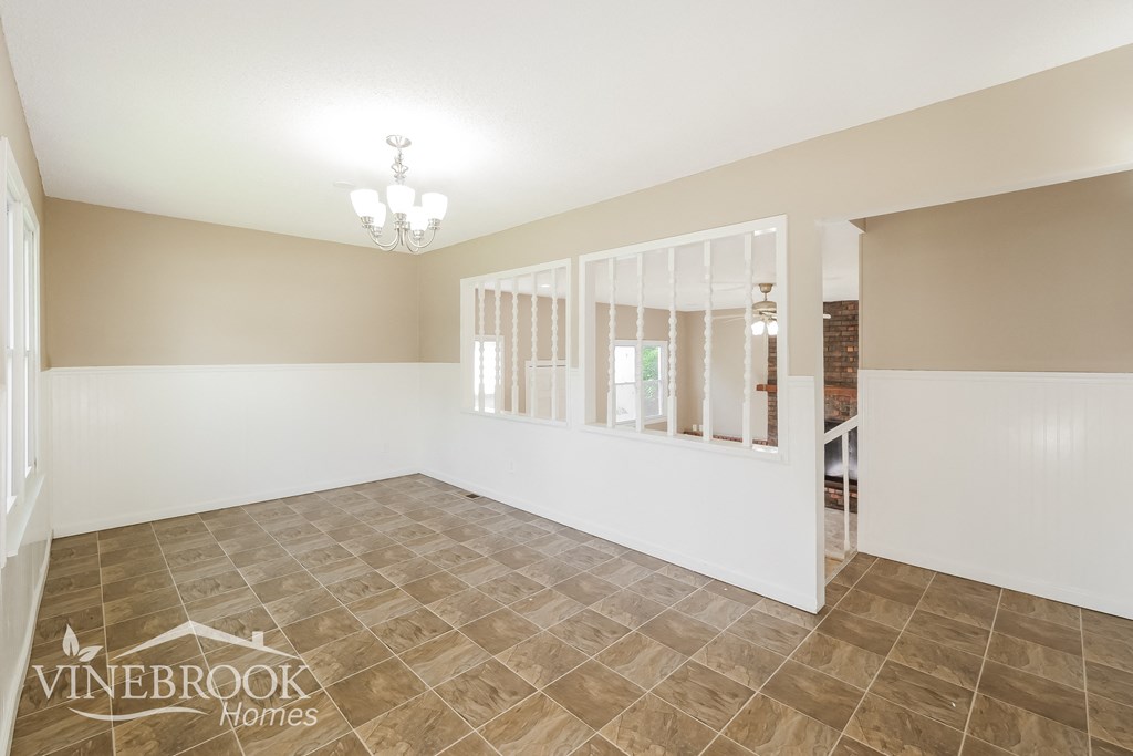 the living room and dining room of a home with tile flooring