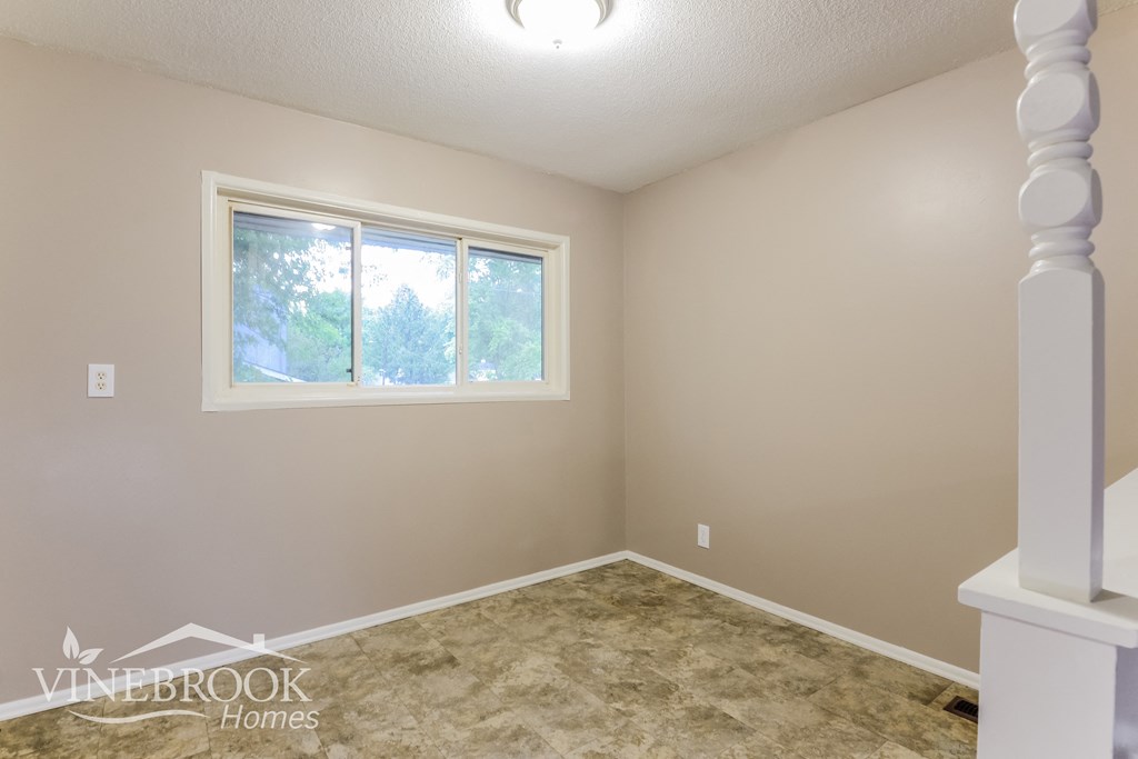 the upstairs bedroom has a large window and a carpeted floor