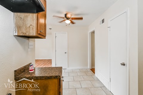 a kitchen with a counter top and a ceiling fan