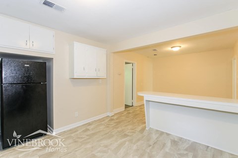 a kitchen with white cabinets and a black refrigerator