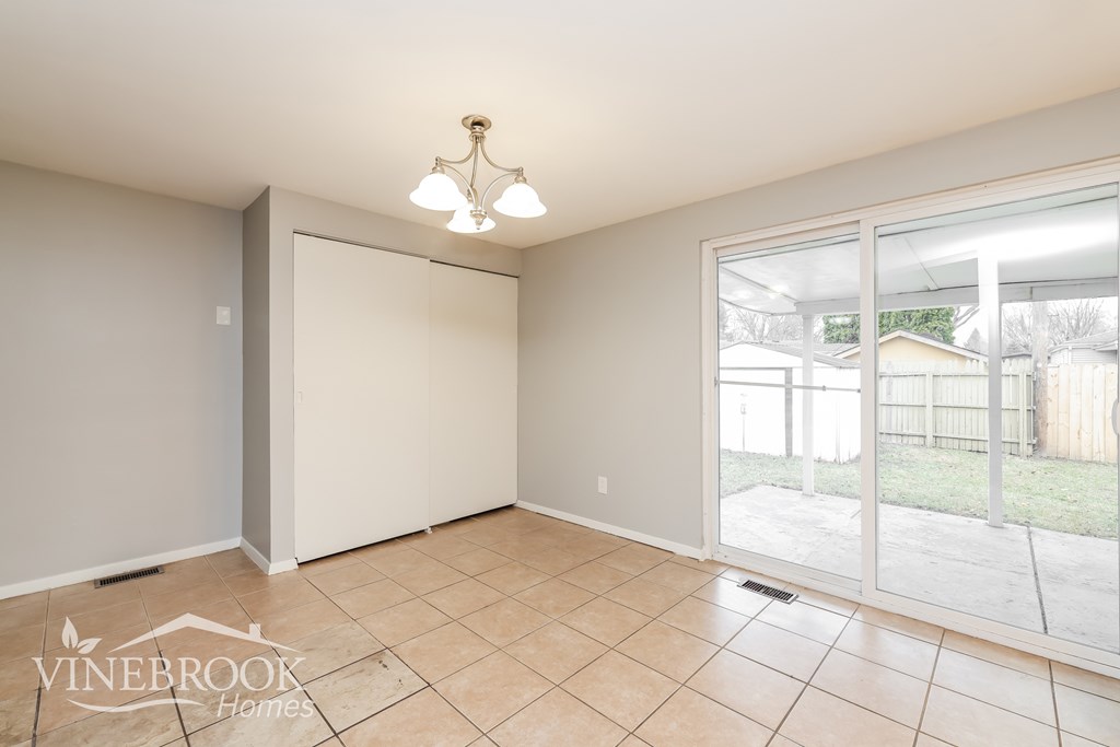 A room with a sliding glass door leading to a backyard.