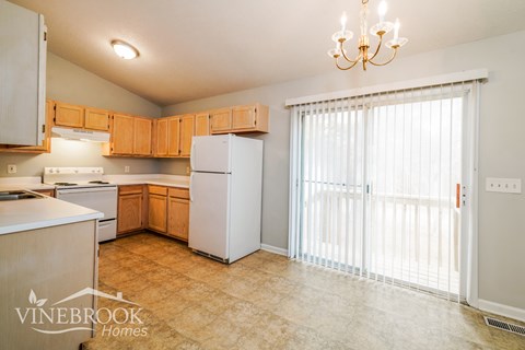 A kitchen with wooden cabinets and a white refrigerator.