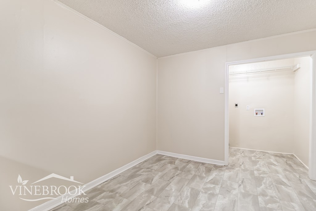 A room with a carpeted floor and a doorway leading to another room.