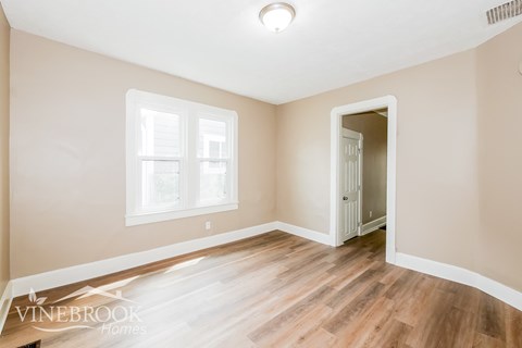 A room with a wooden floor and a white door.
