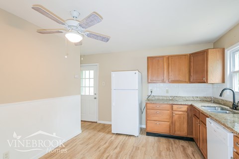 A kitchen with wooden cabinets and a white refrigerator.