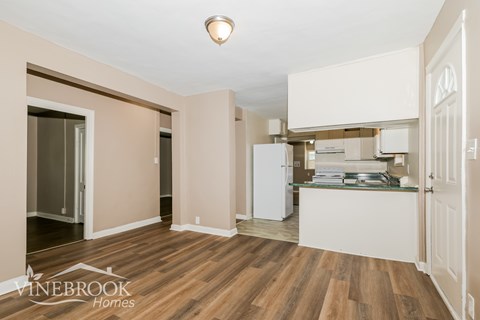 A kitchen area with a refrigerator, cabinets, and a countertop.