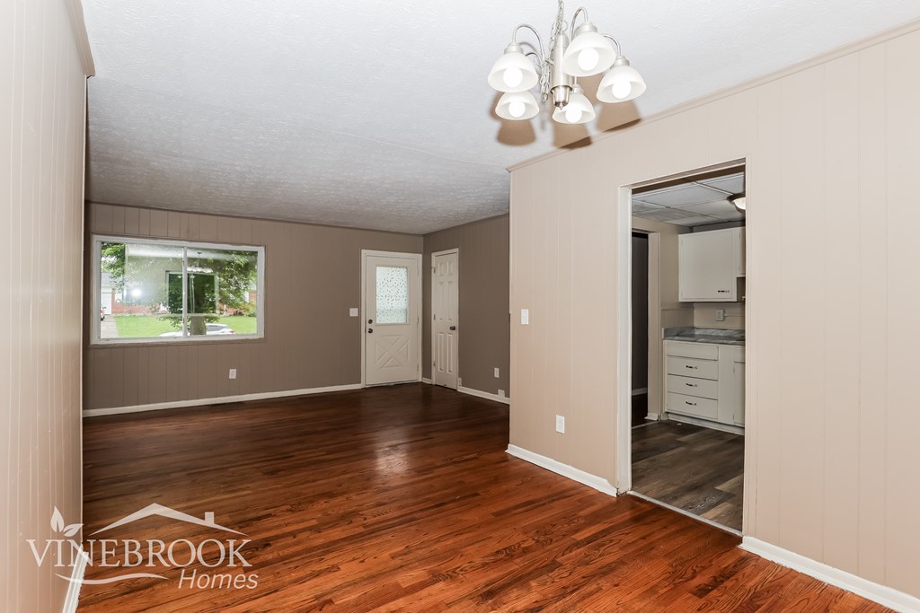A room with wood floors and a large window.