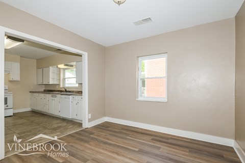 A room with a window and a wooden floor.