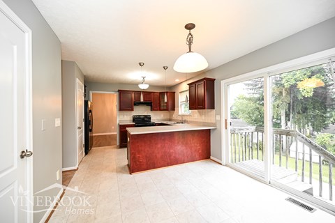 A kitchen with a red counter top and white cabinets.