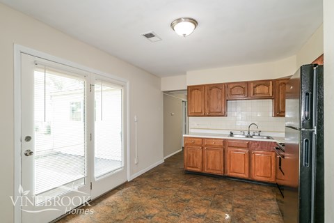 A kitchen with wooden cabinets and a refrigerator.