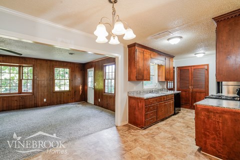 A spacious kitchen with wooden cabinets and a large island.