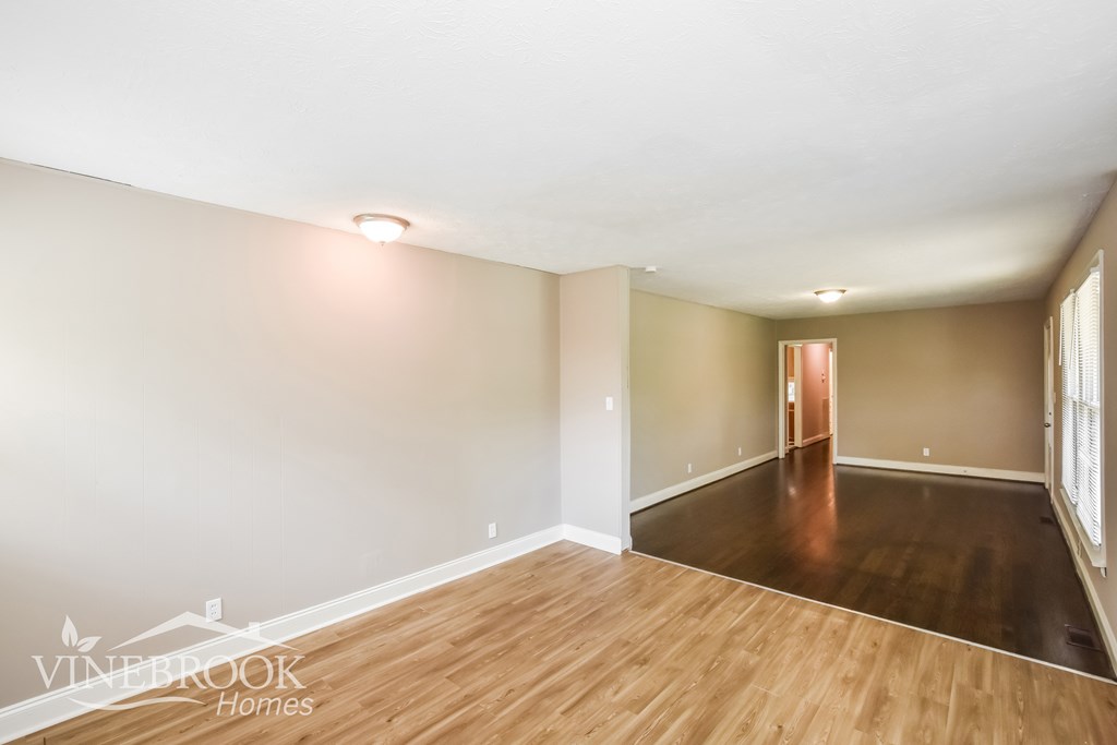 A room with wooden flooring and a white wall.