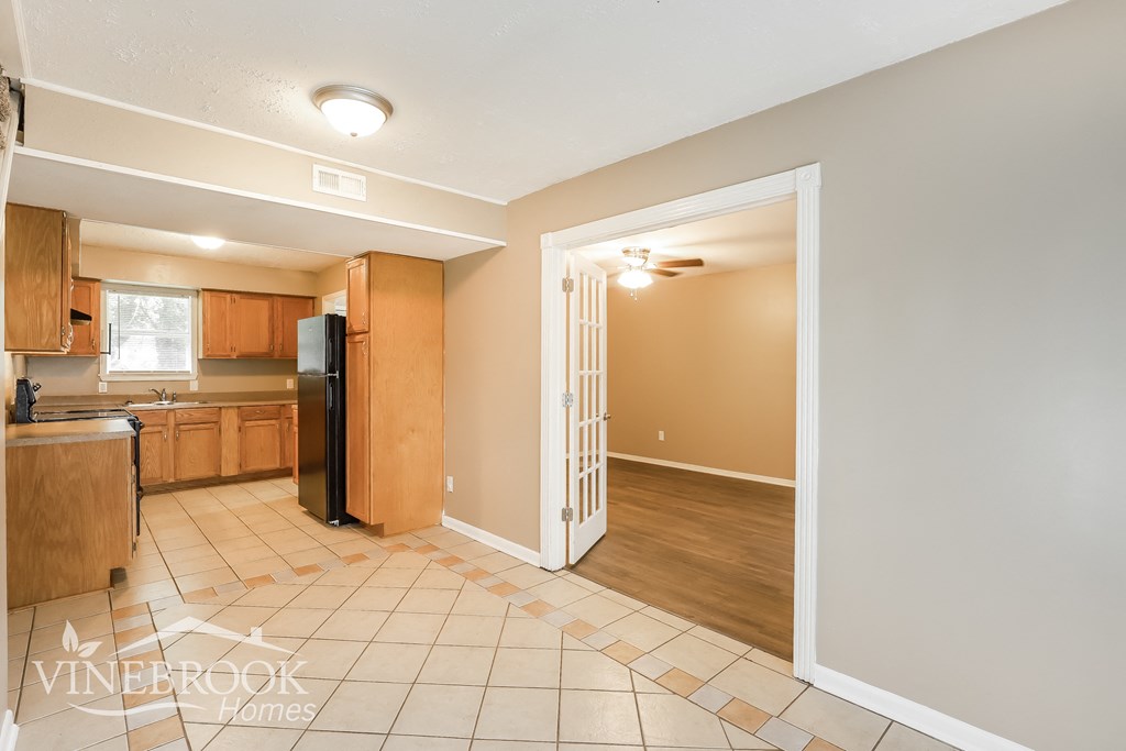 a kitchen and dining room with a door to the living room
