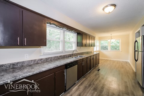 a kitchen with dark cabinets and a counter top and a sink