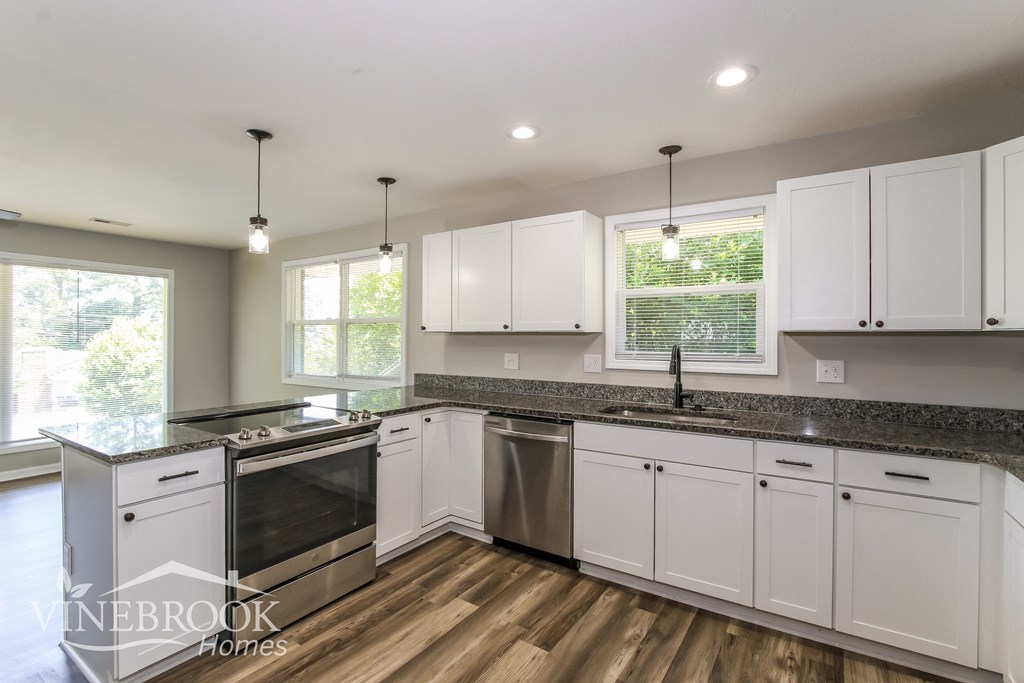 A kitchen with white cabinets and a stainless steel dishwasher.
