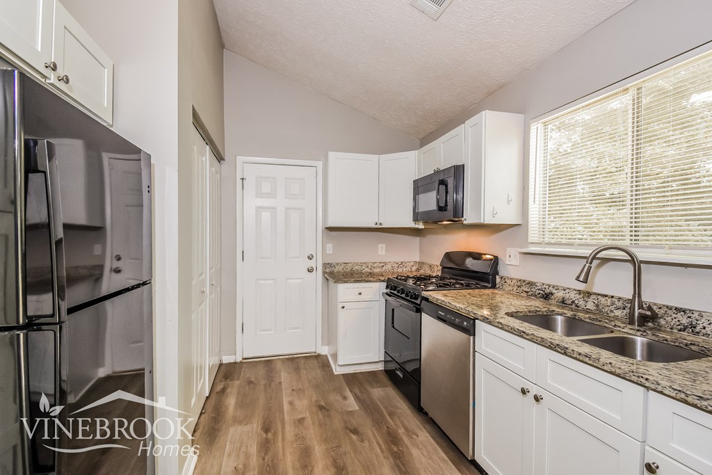 a kitchen with white cabinets and stainless steel appliances