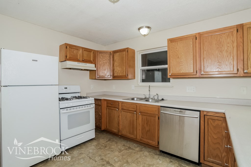 a kitchen with white appliances and wooden cabinets
