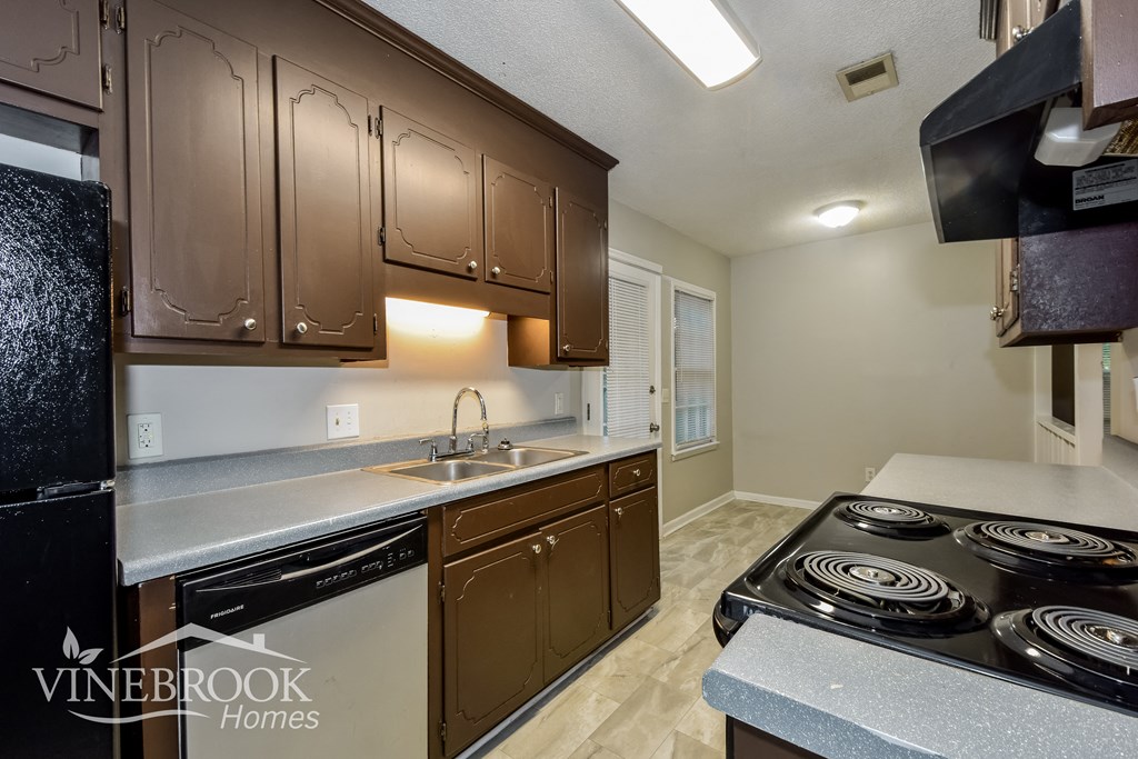 a kitchen with a stove top oven and a sink