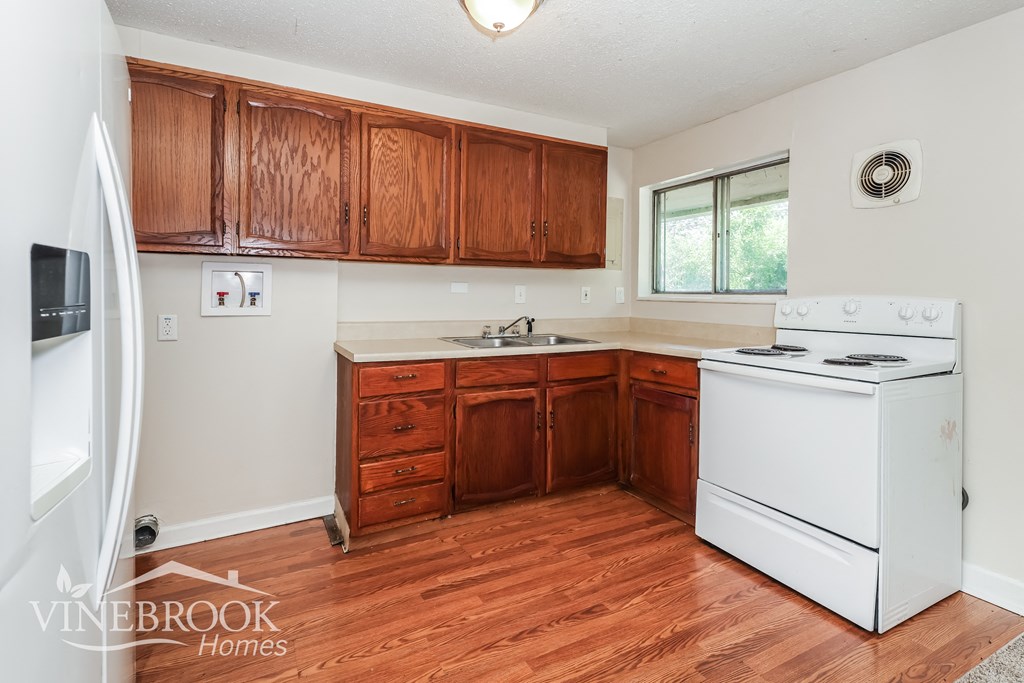 a kitchen with white appliances and wooden cabinets