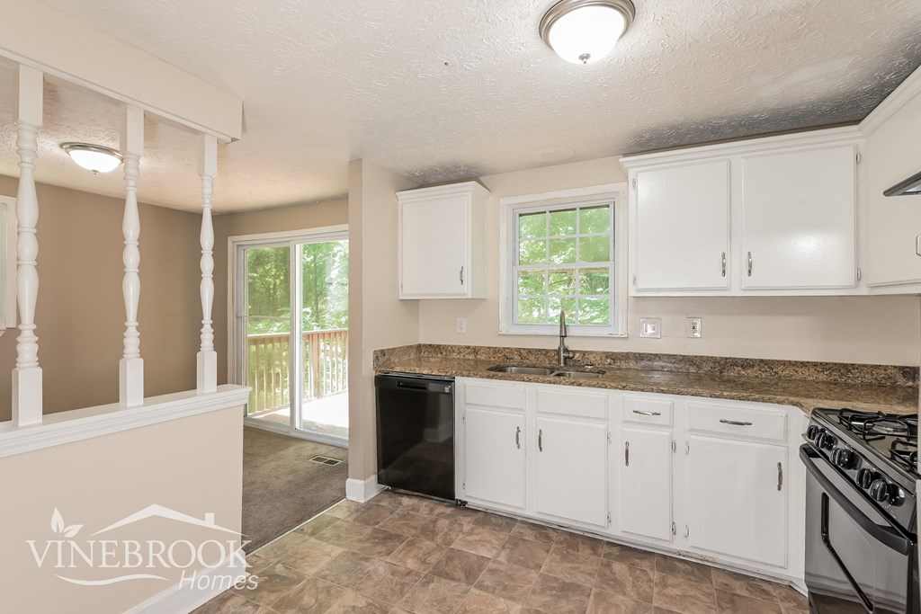 a kitchen with white cabinets and a counter top and a sink