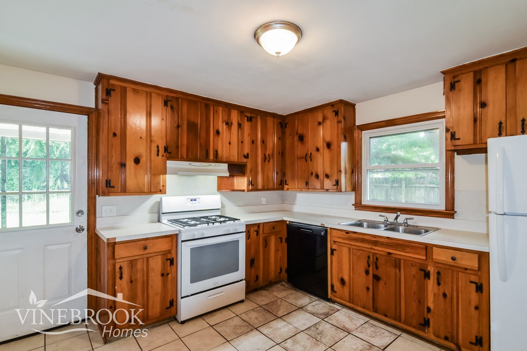 a kitchen with wood cabinets and white appliances