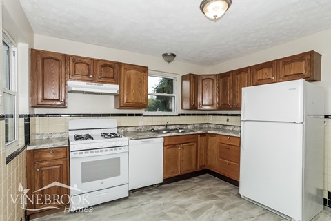 a kitchen with white appliances and wooden cabinets