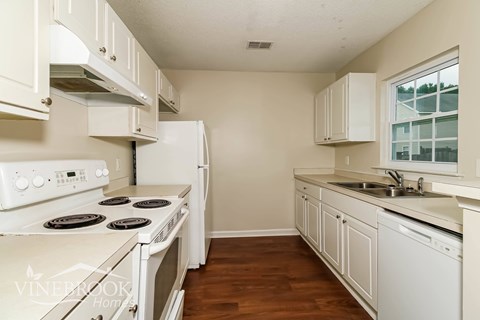 a white kitchen with white appliances and white cabinets